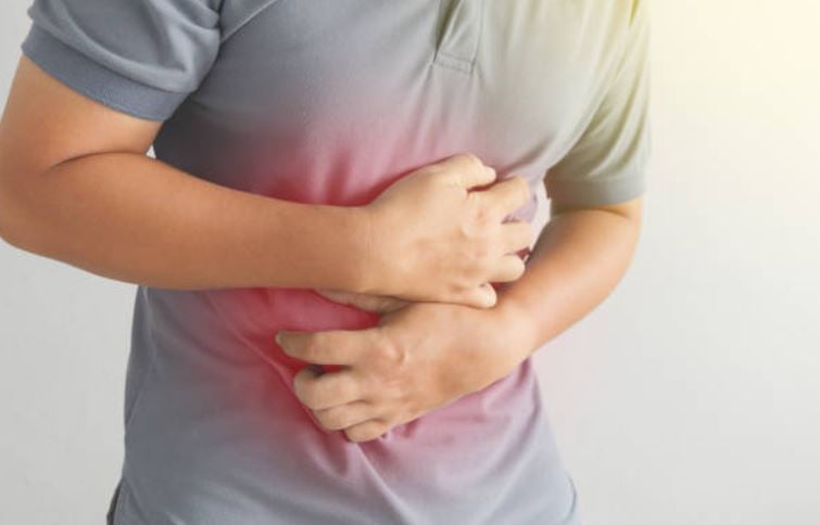 Homme se tenant l’estomac avec douleur, souffrant de brûlures gastriques et de reflux